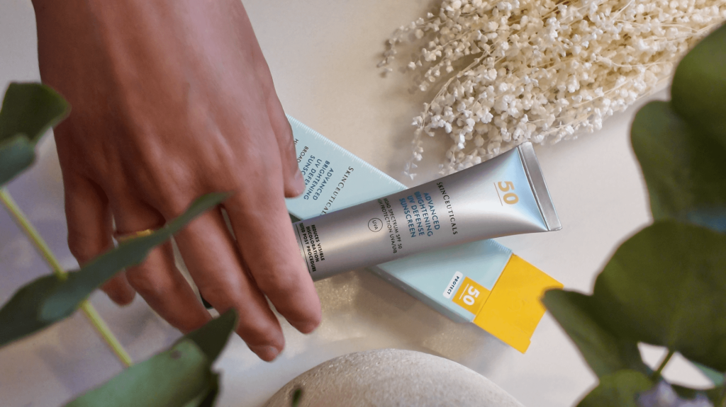 Crema solar y mano sobre mesa