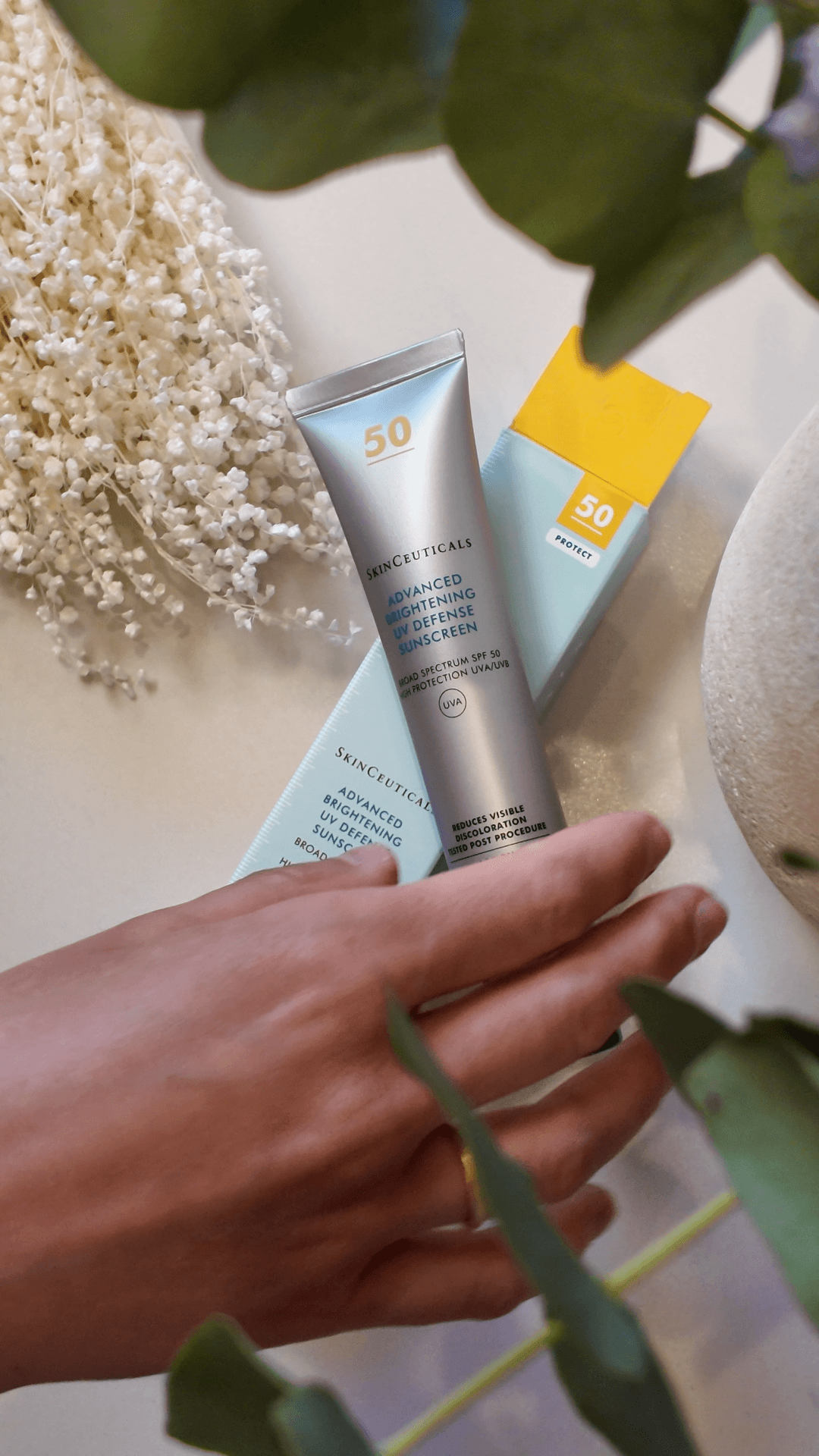 Crema solar y mano sobre mesa