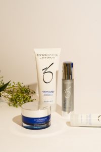 Flatlay de productos de skincare con retinol, niacinamida y crema hidratante sobre fondo neutro
